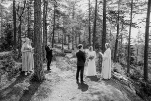Sort-hvitt oversiktsbilde av vielsen som finner sted i skogen.