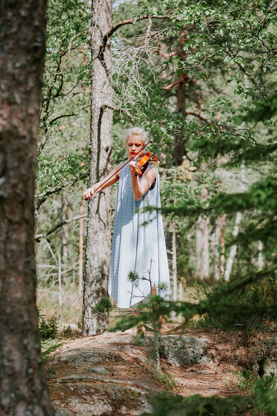Fiolinist som spiller mens bruden går inn. Fiolinisten er barføtt og står i lyngen.