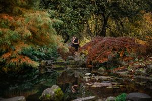 Engagement photo in Japanese garden with fall colors and stone pathway.