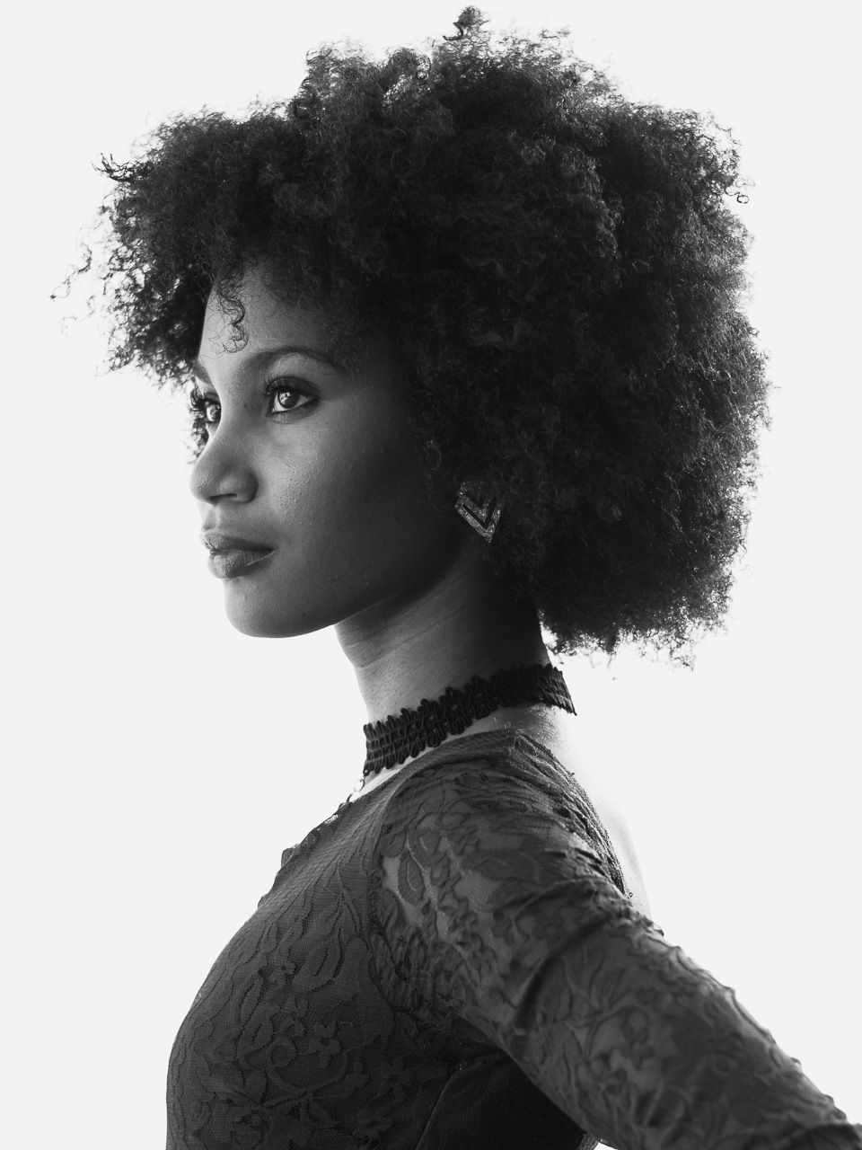 Black and white profile portrait showing a natural afro hairstyle and formal dress with lace details.