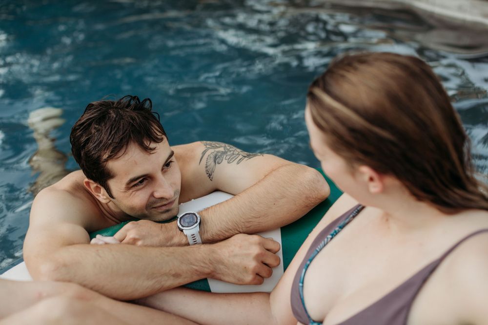 Couple enjoying playful moments while relaxing on pool float.