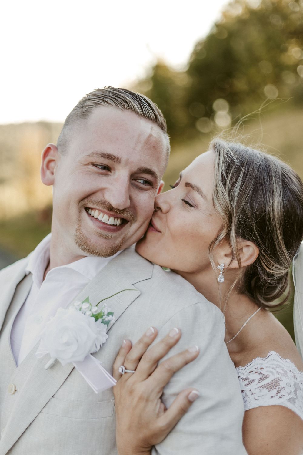 Intimate wedding portraits capture sweet moments between newlyweds in white formal attire against a golden sunset.