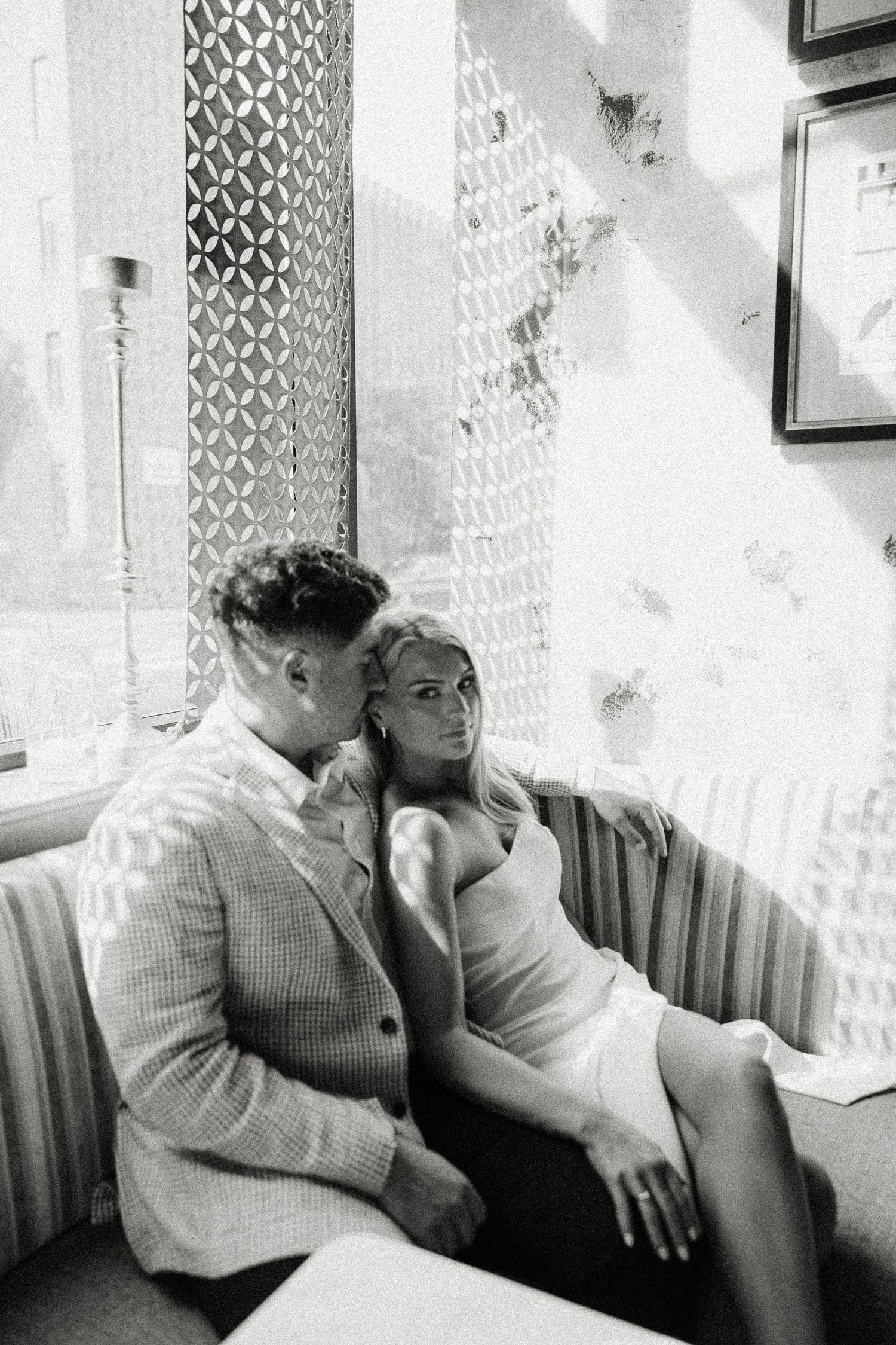 Black and white photo of couple sitting intimately in a vintage booth at Gracie's restaurant. Providence RI. Miranda Photo & Co