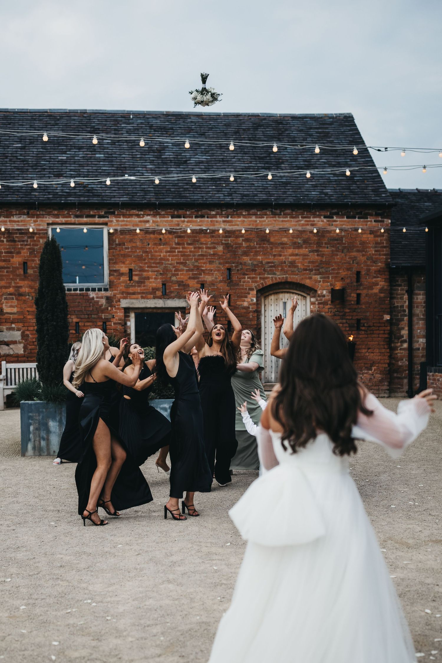 Bride tossing bouquet to bridesmaids Grangefields