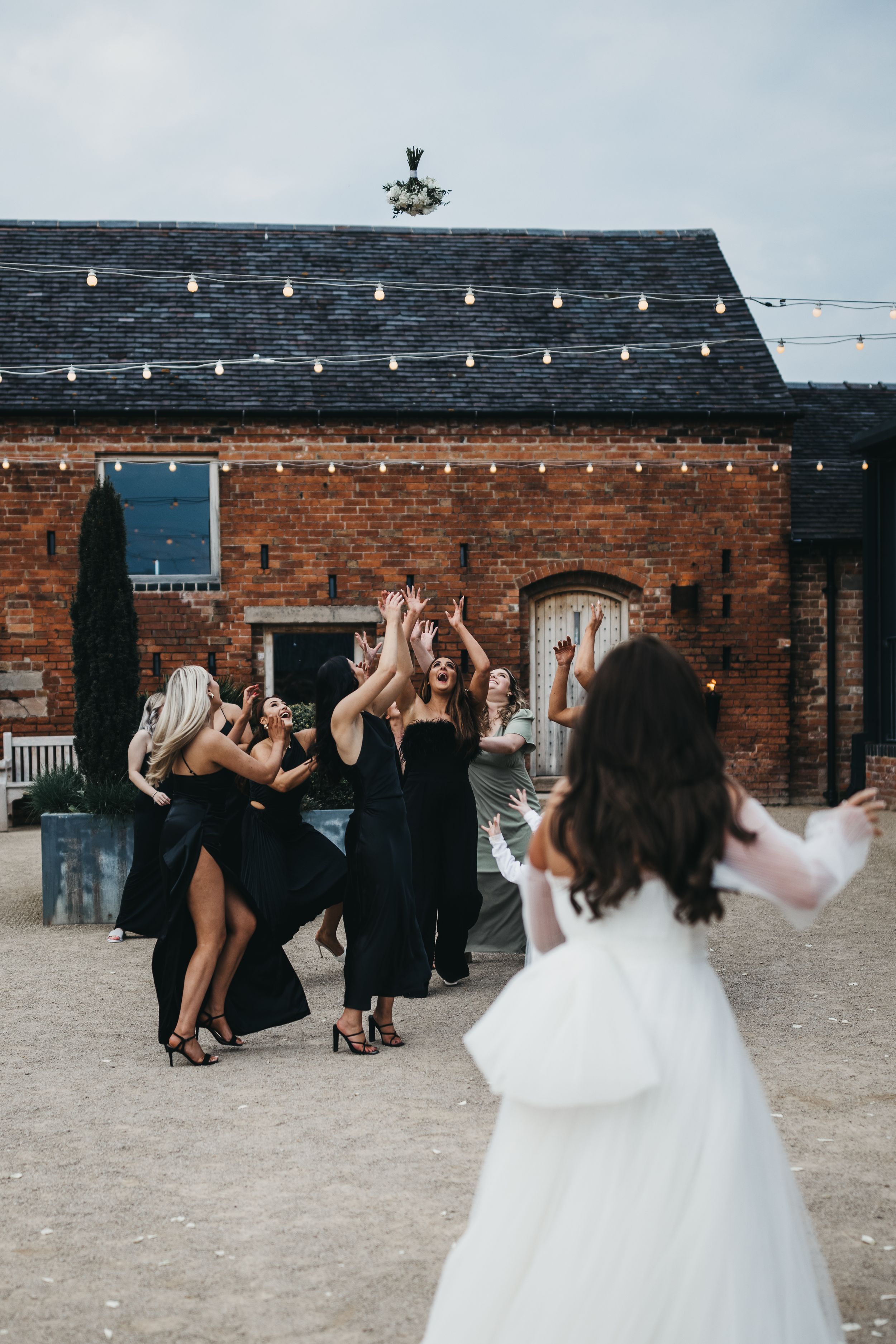 Bride tossing bouquet to bridesmaids Grangefields