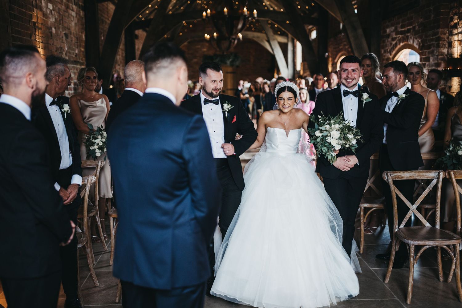 A bride approching her groom at Grangefields Barn wedding venue smiling at him