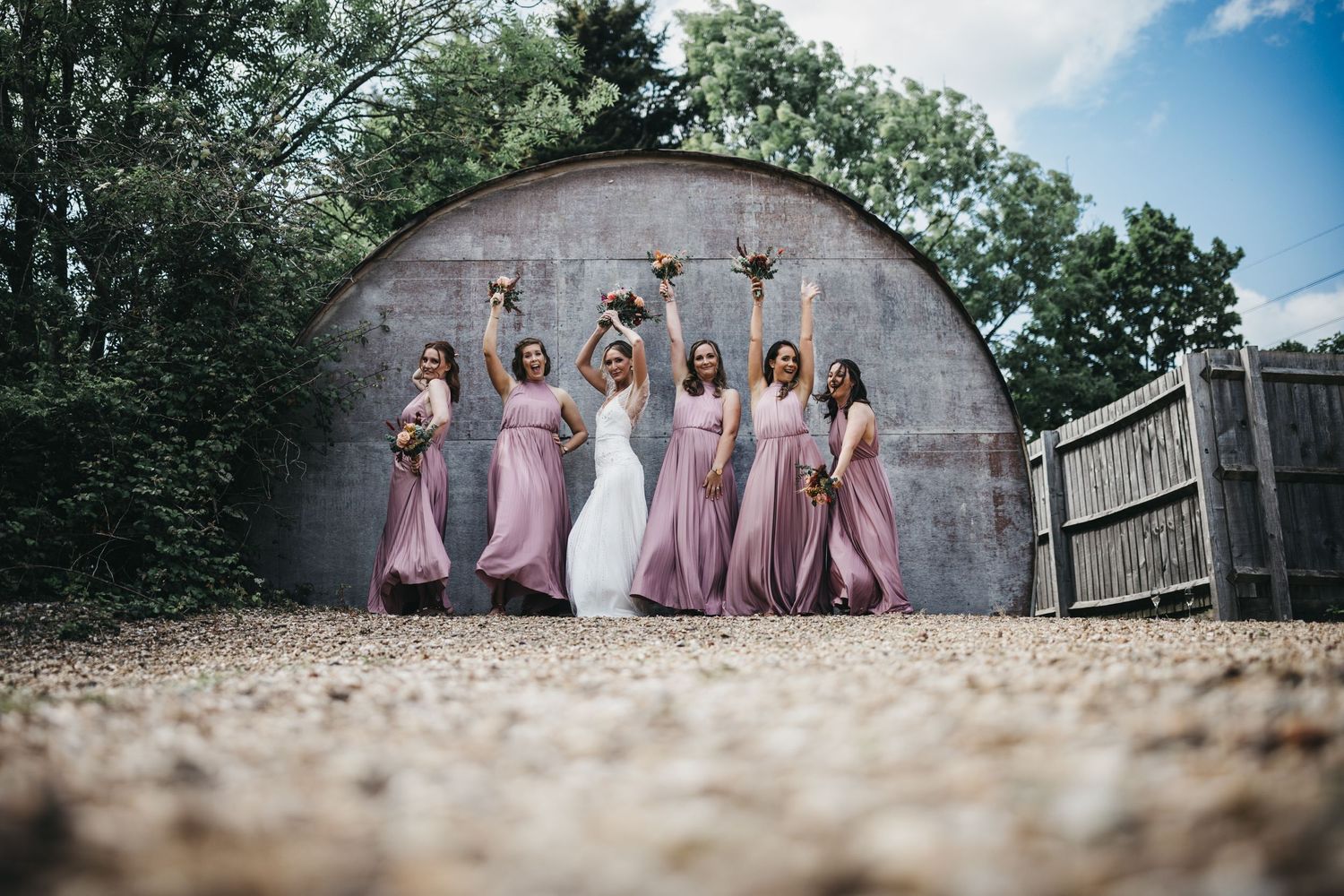 Bride and her bridesmaids at the Carriage Hall dancing in front of building