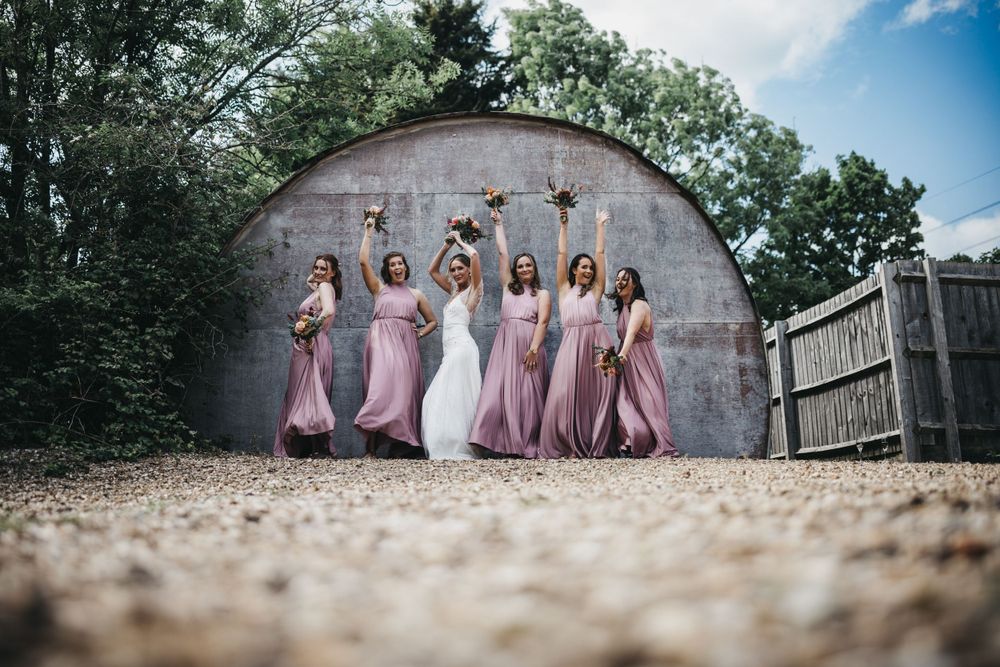 Bride and her bridesmaids at the Carriage Hall dancing in front of building