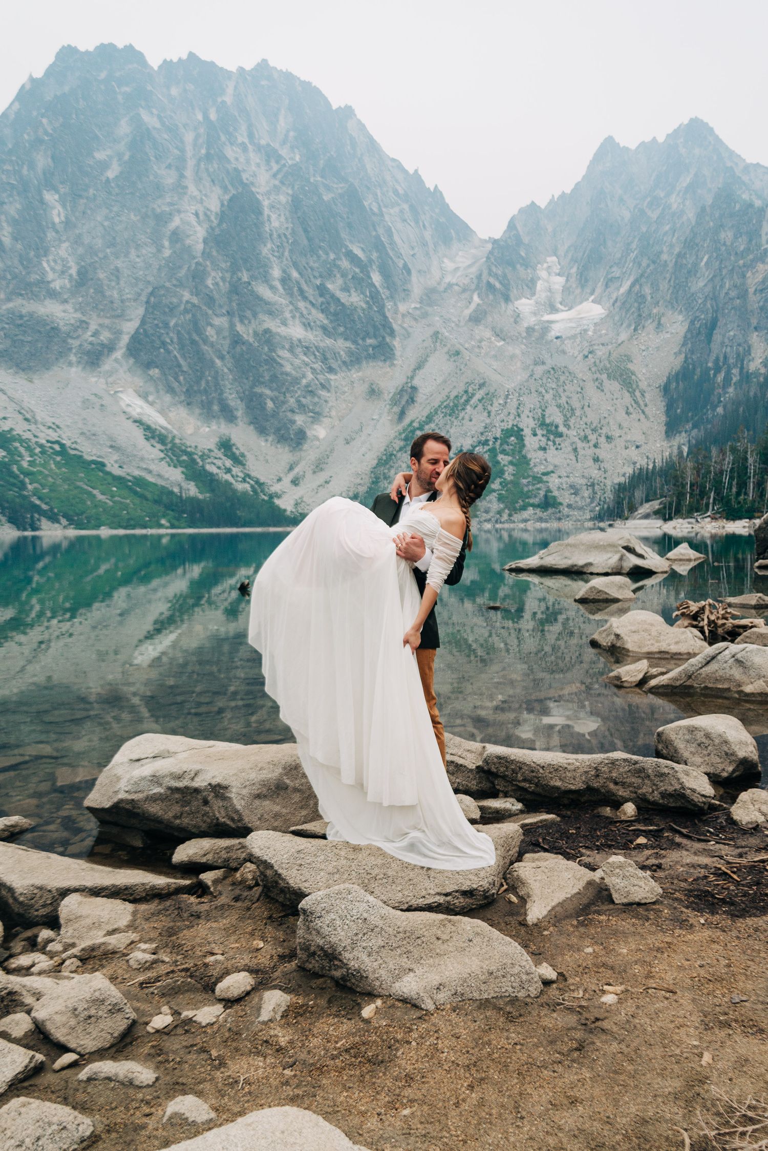 Groom holding bride after epic hiking destination wedding at Culchuck lake
