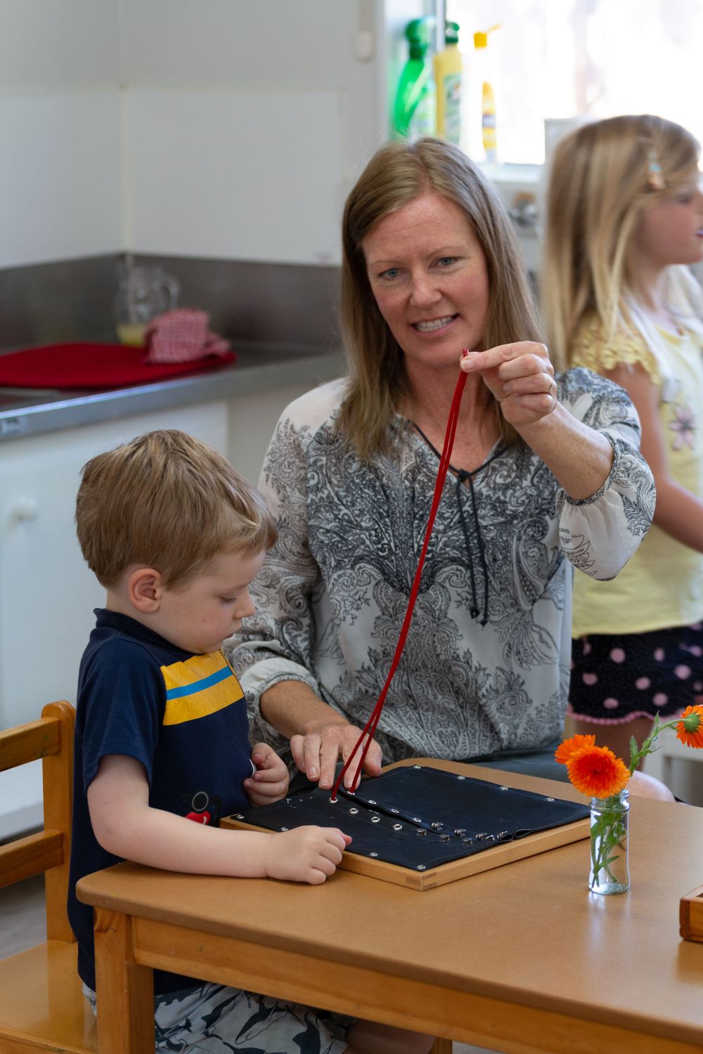 An educational activity taking place at a table in a classroom setting.