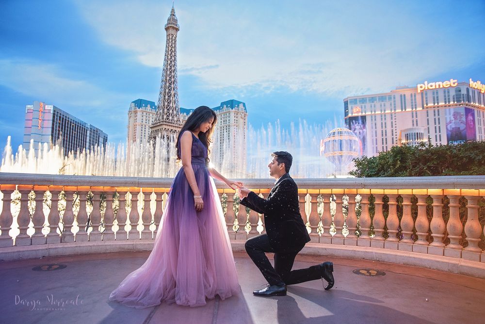 A proposal scene at the Bellagio fountains with the Eiffel Tower replica in the background.
