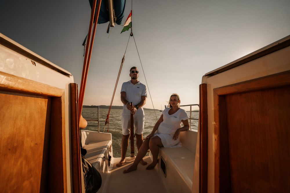 Couple enjoying a sunset moment on deck of a sailing boat.