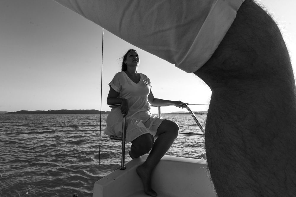 Black and white image of sailing crew members managing controls on a yacht.