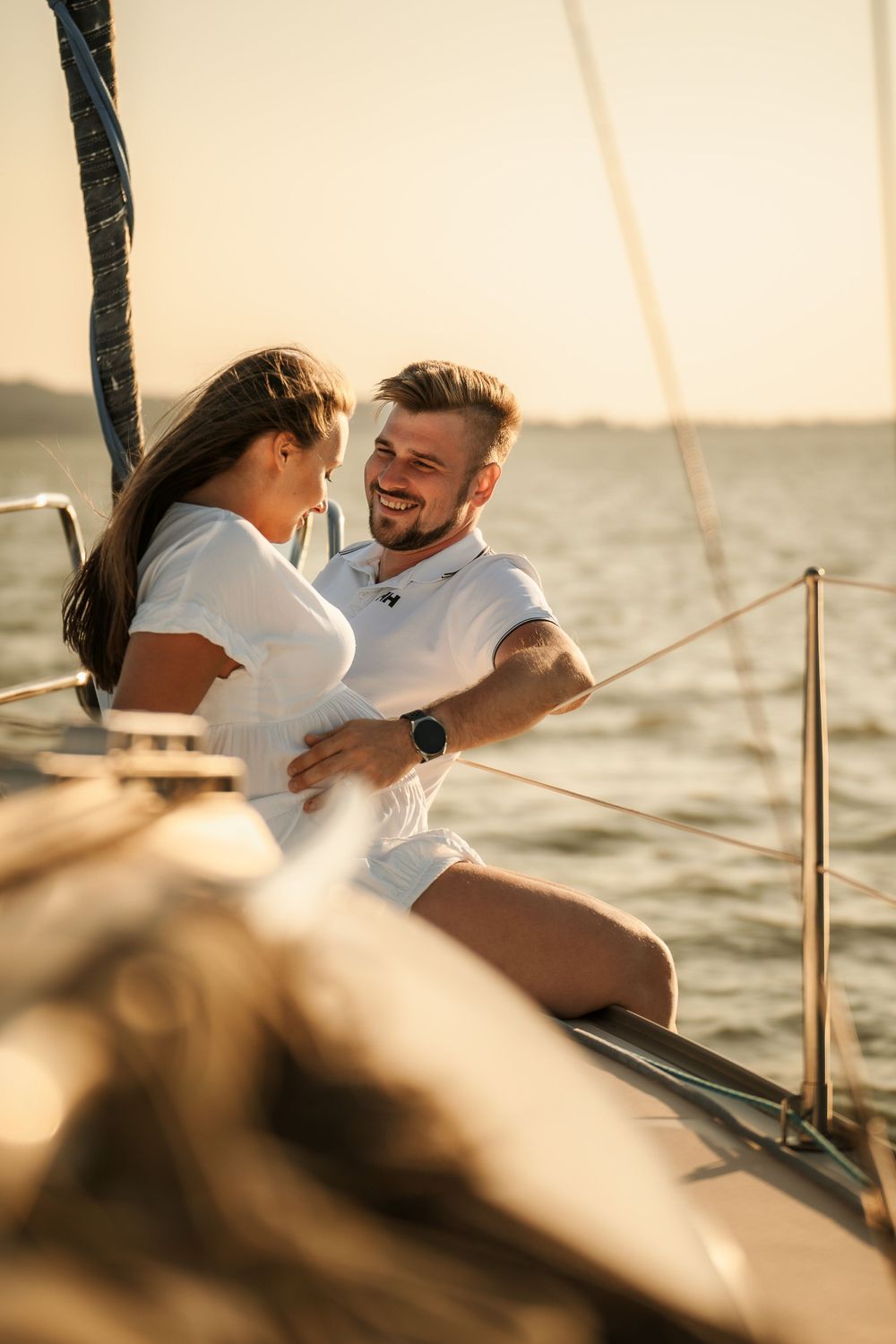 Two people sharing laughter while sailing together during golden hour.