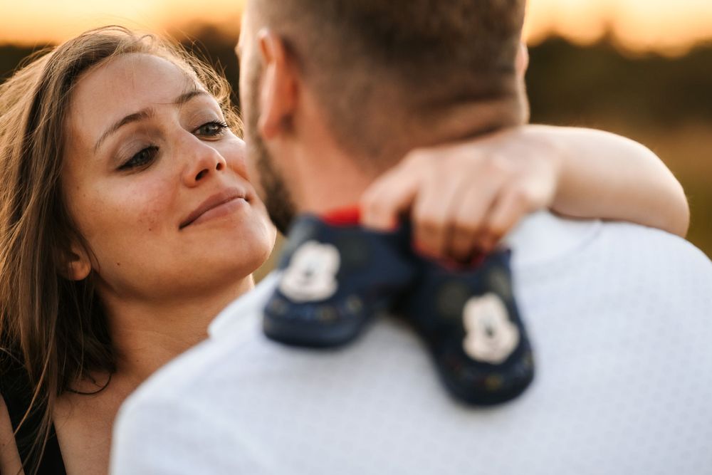 Intimate moment captured between couple during sunset maternity shoot.