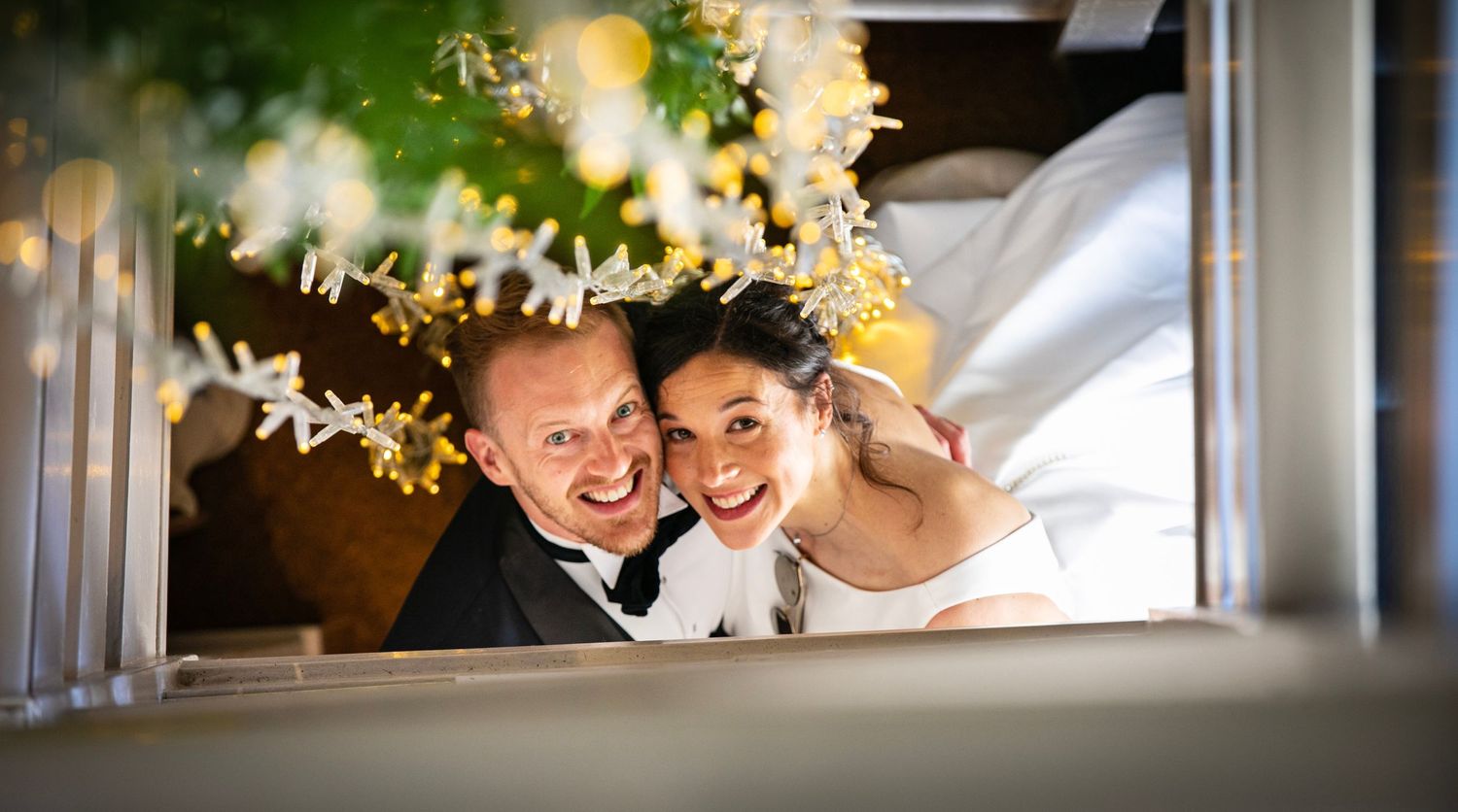 Romantic wedding moments captured through decorative window frames with natural greenery.