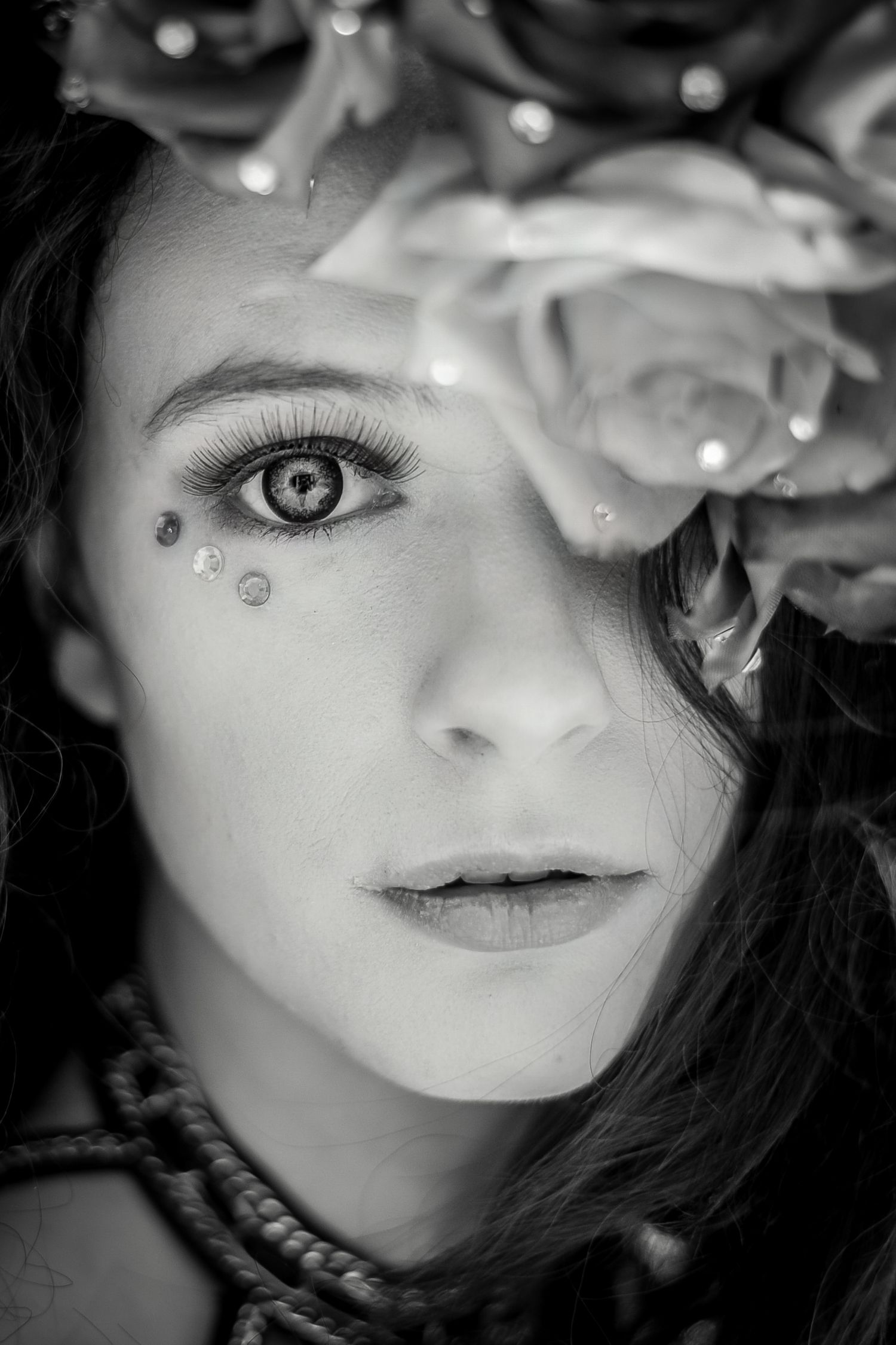 An artistic black and white portrait with delicate rhinestone details and white flowers.