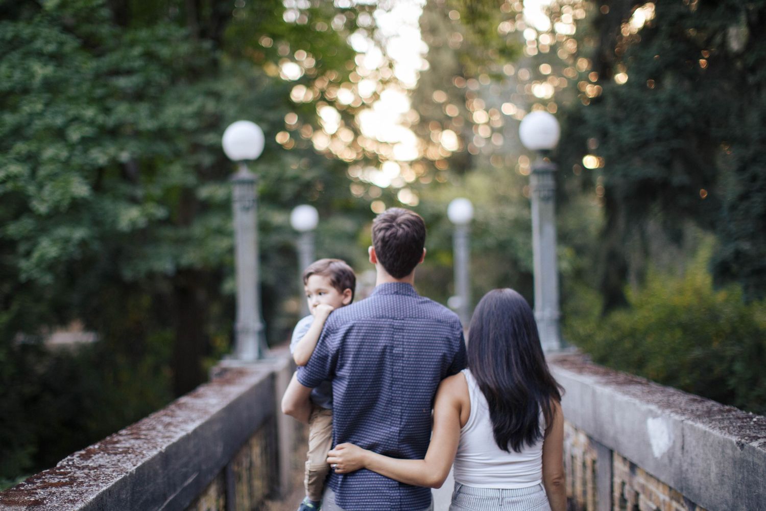 Seattle family photography: a mother, father carry their son, at UW Arboretum in Seattle