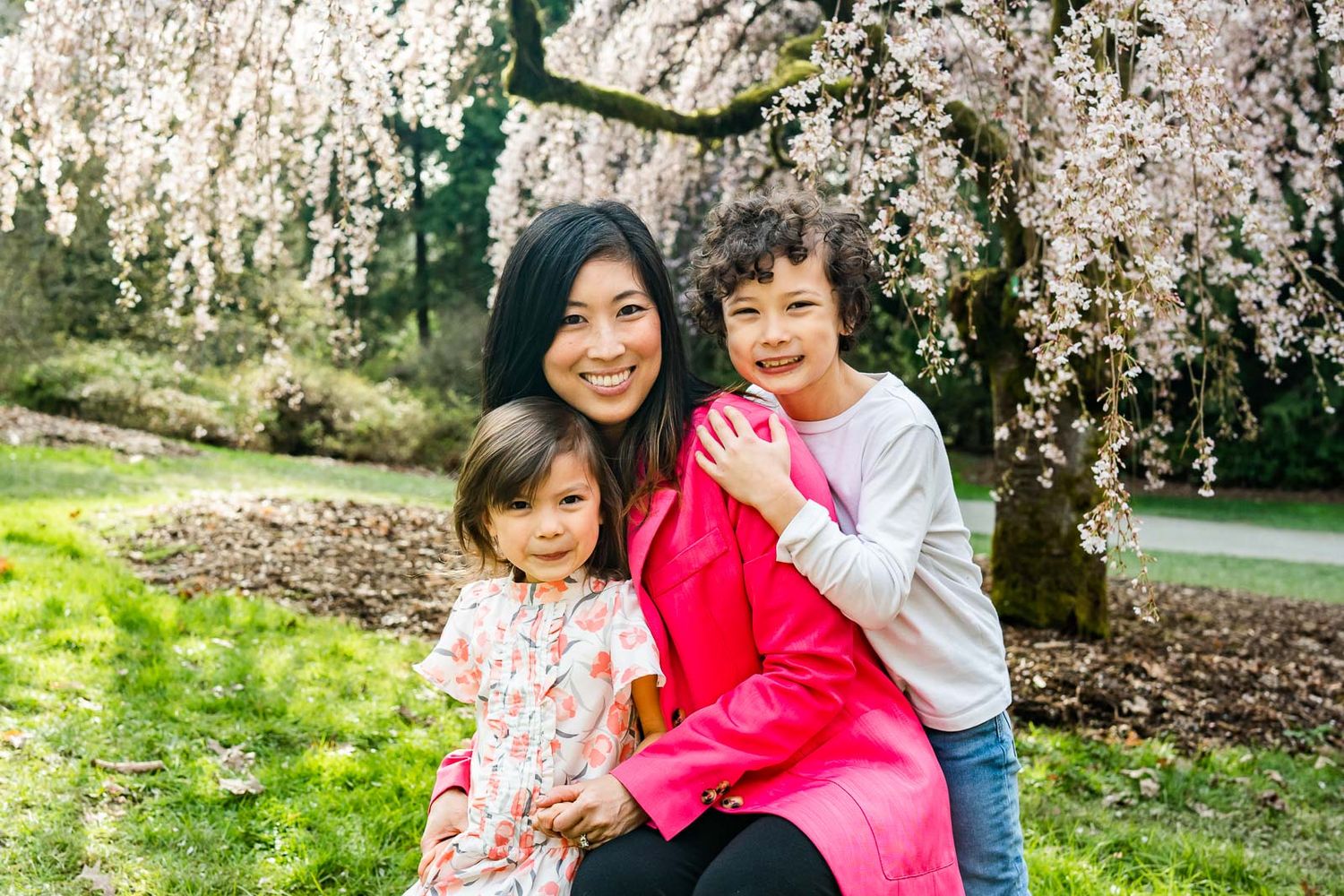 Mother and children smile and enjoy the cherry blossoms in Seattle