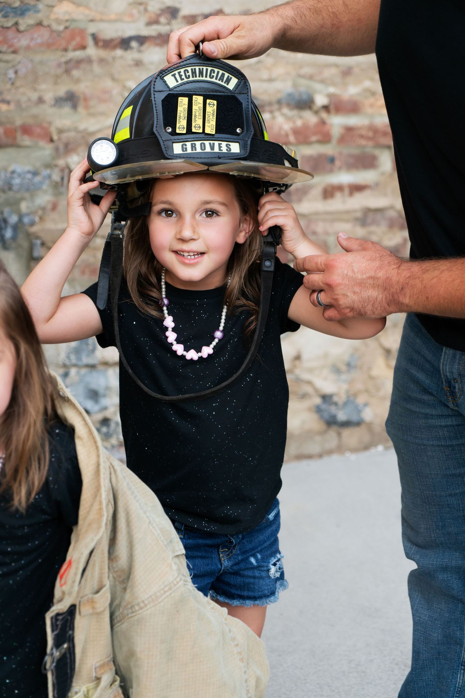 girl tries on firefighter dad's helmet