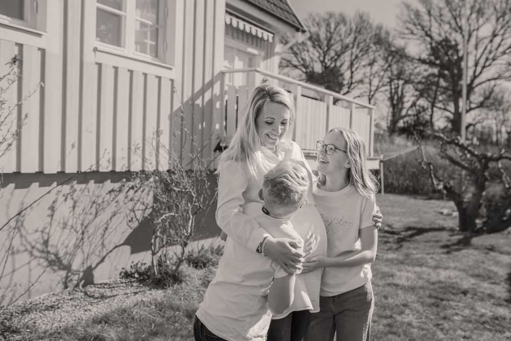 Spring outdoor portrait in front of a white wooden house with bright natural lighting.