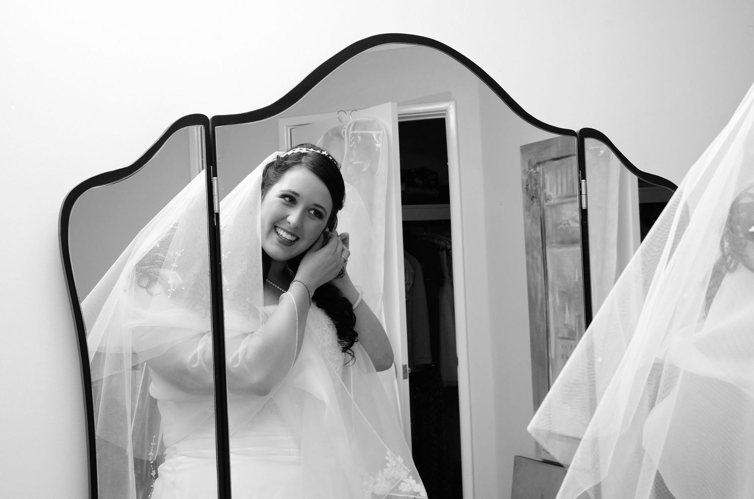 bride getting ready looking at her reflection in mirror