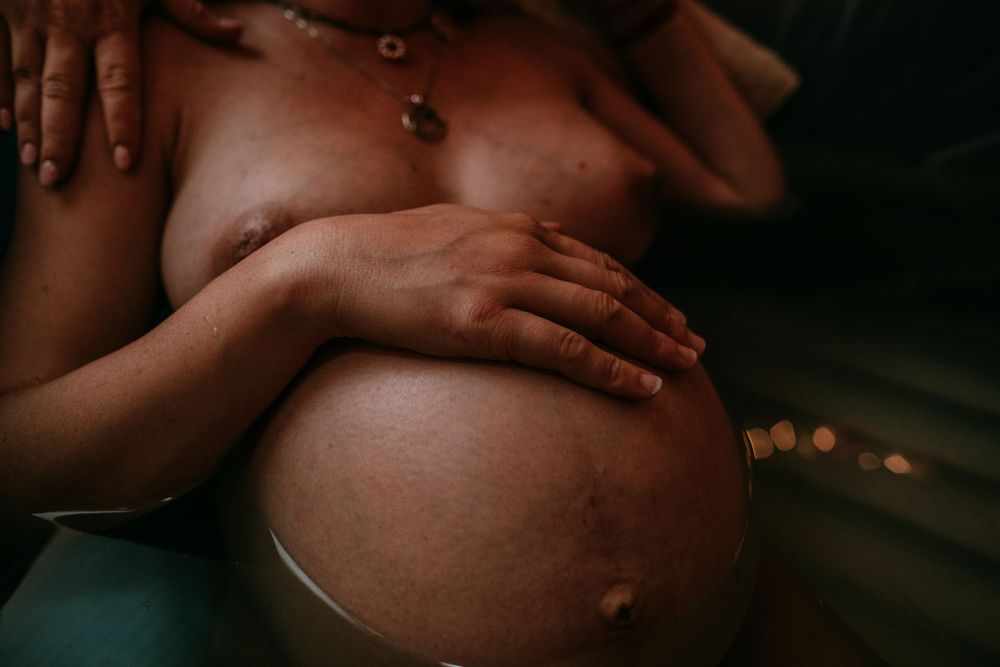 birthing person holds belly water birth portland oregon birth photographer
