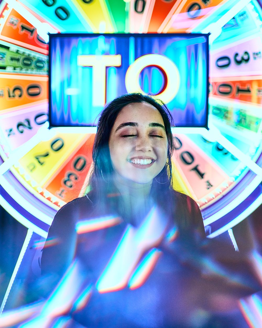 Model smiling in front of neon backlit gaming wheel with glowing numbers and patterns.