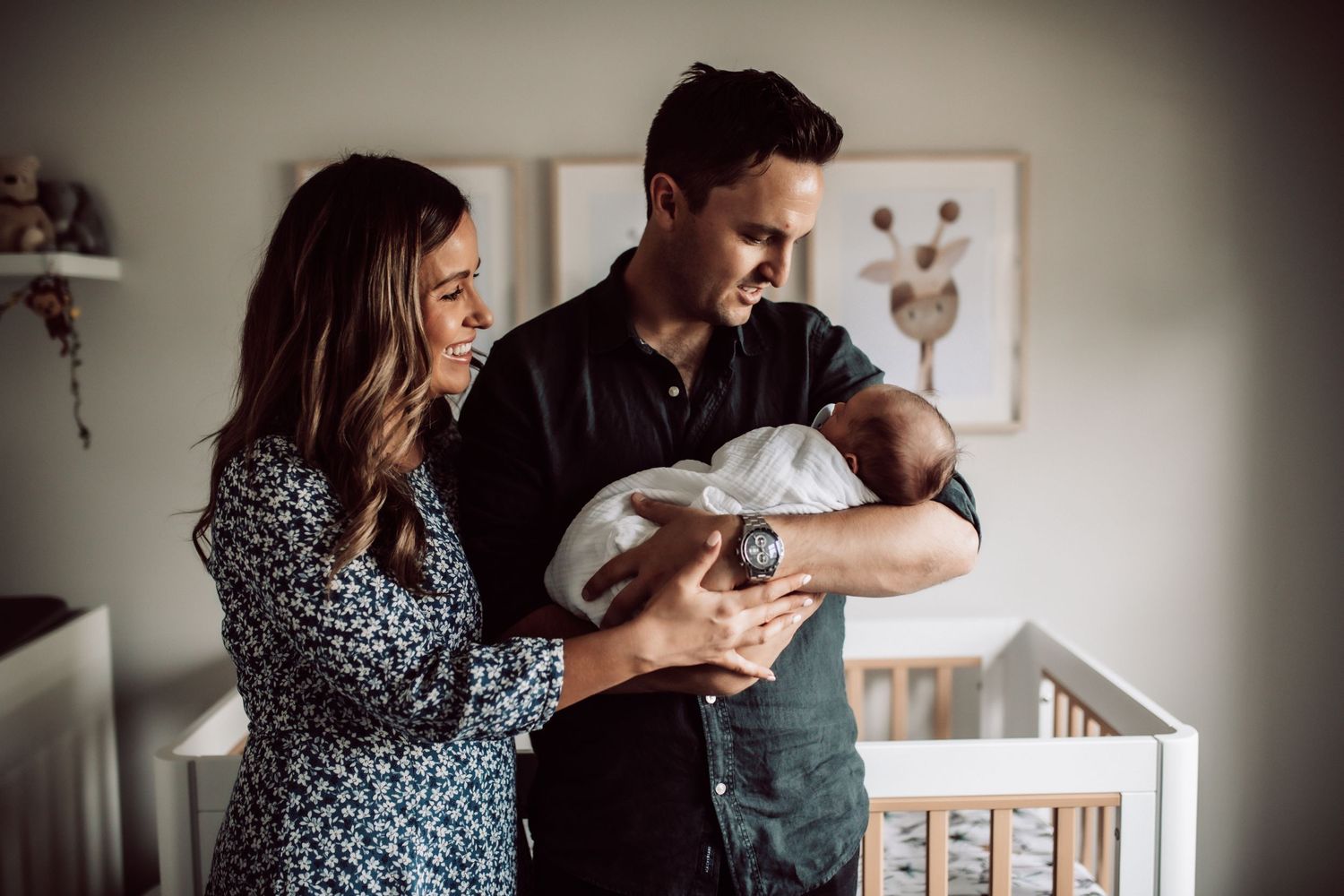 Sweet family bonding moments captured in moody indoor lighting near a window.