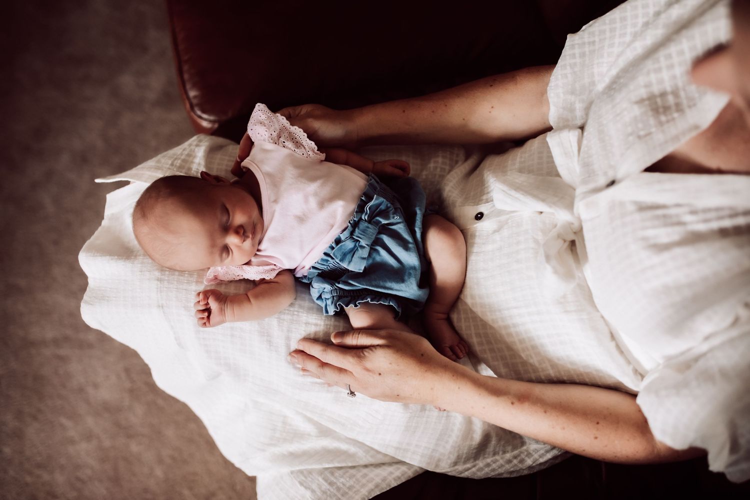 Artistic black and white family portraits showing tender moments on white fabric.