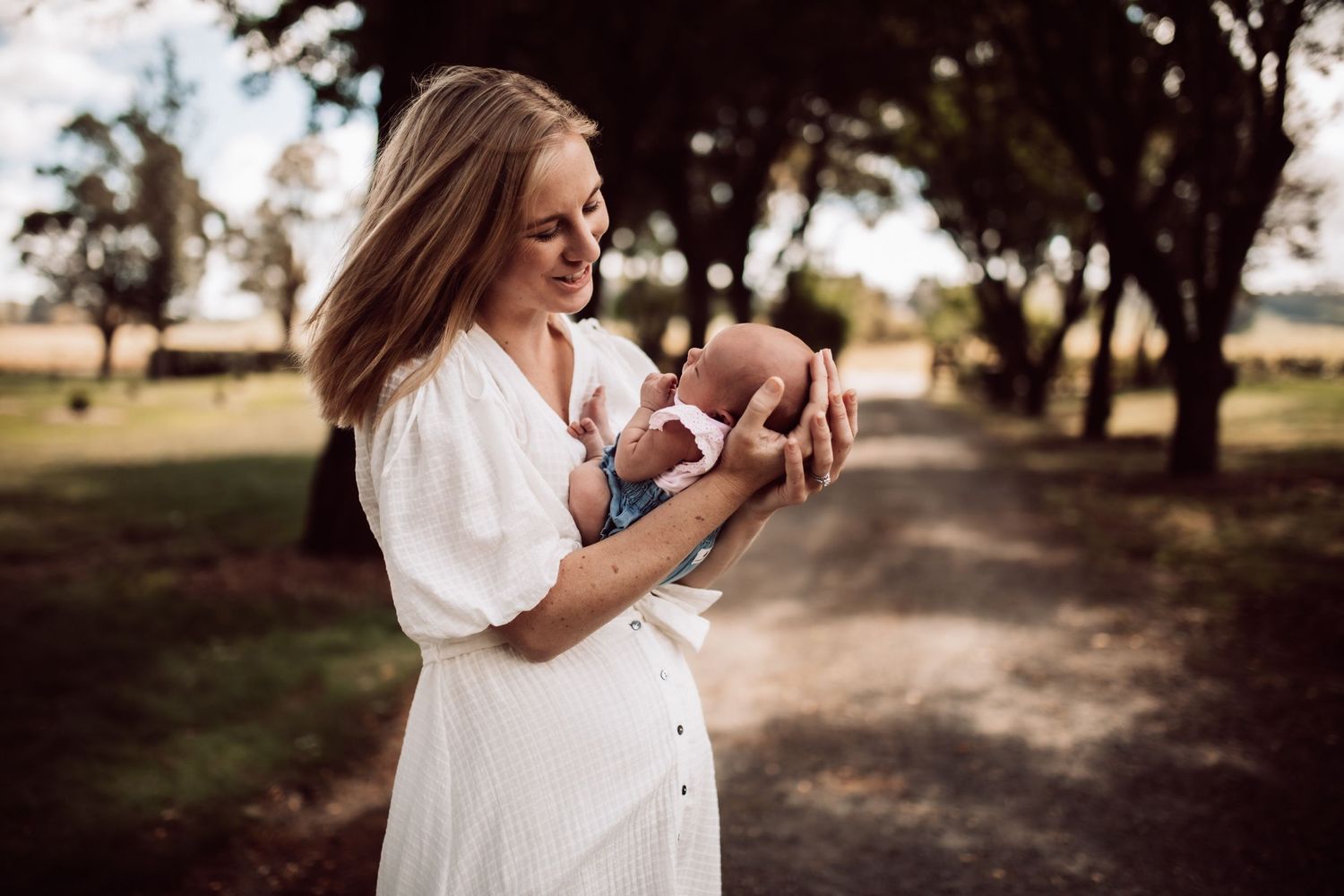 Outdoor family photoshoot in a natural setting with trees and golden afternoon light.