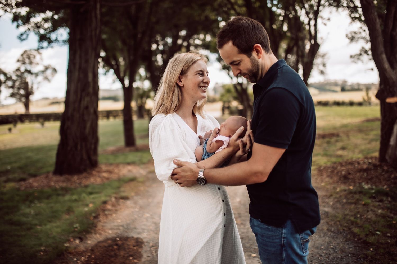Natural light family photography session among trees with golden sunset lighting.