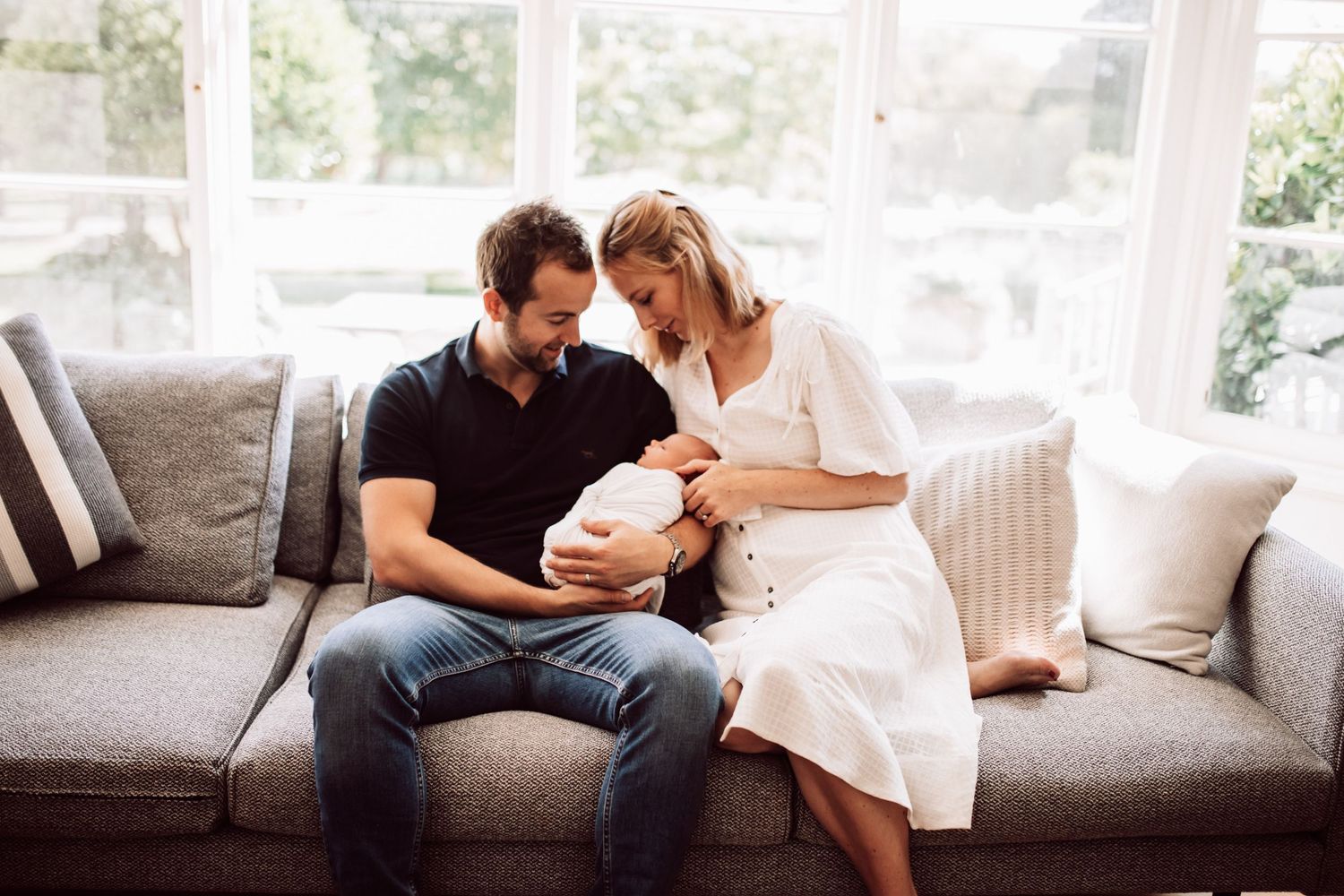 Lifestyle family photography session in a bright sunlit room with white decor.