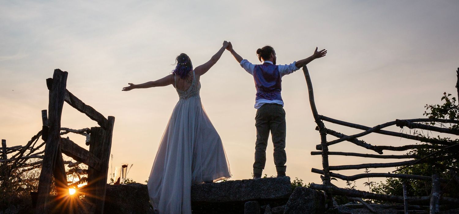 Silhouettes of people celebrating against a dramatic sunset sky.