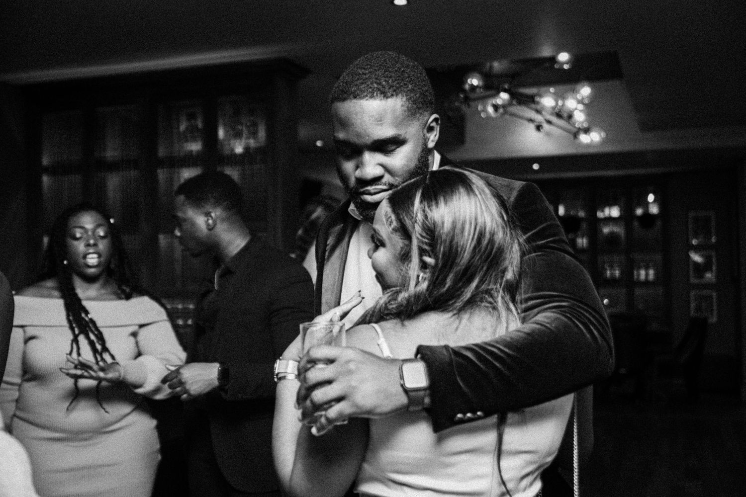 A black and white photo of couples slow dancing in an intimate setting.