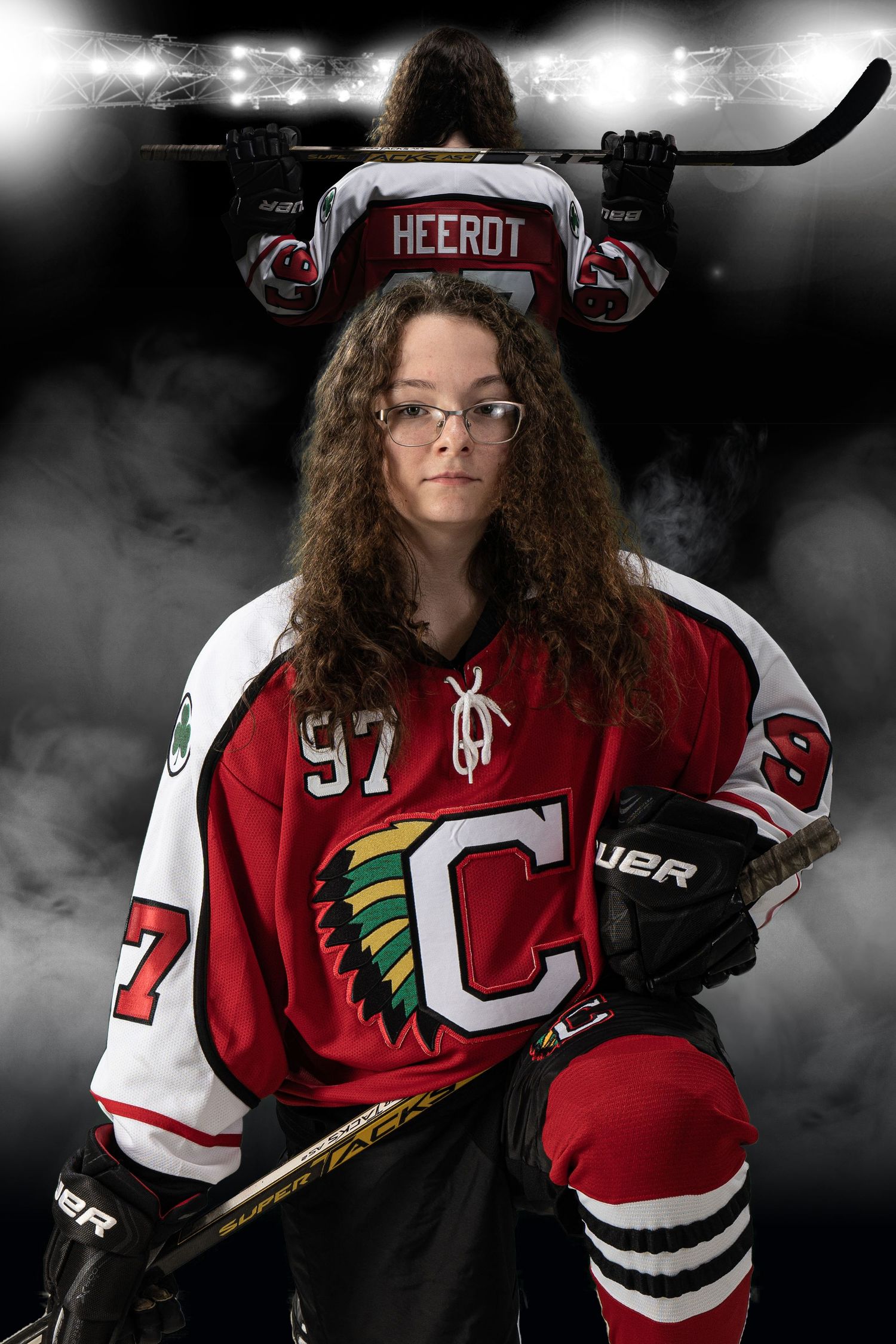 Hockey player wearing red and white jersey with native american logo poses dramatically.