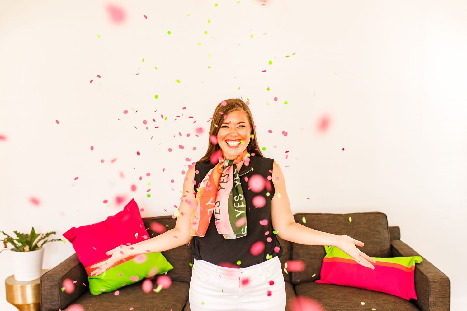 brand photo of a young white woman with brown hair pink and green confetti