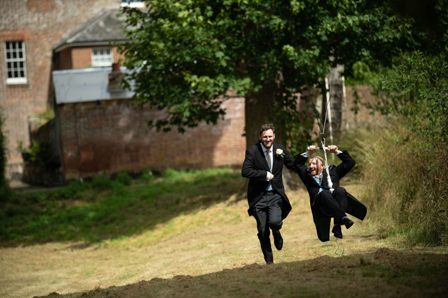 two grooms share a zipline during their wedding reception at swarling manor