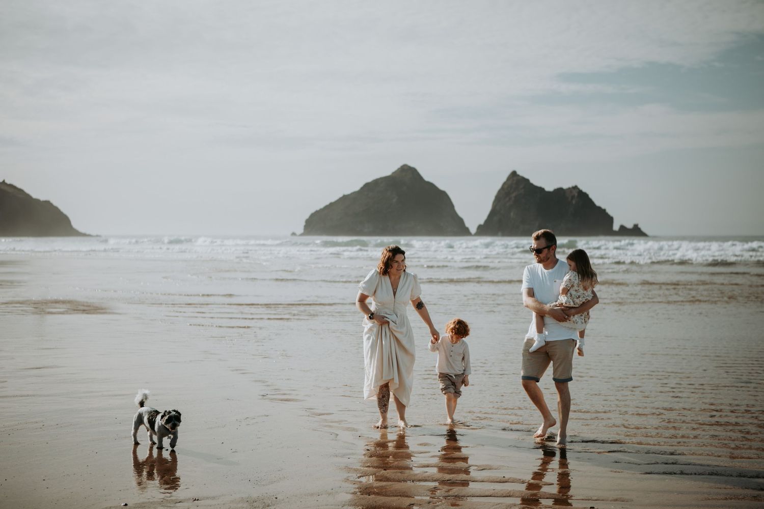 family play on the beach with their dog at Holywell Bay for a family photoshoot