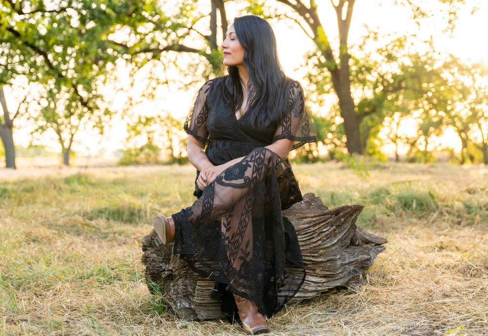 Mysterious and captivating woman adorned in a stunning black dress, in the warm golden glow of golden hour