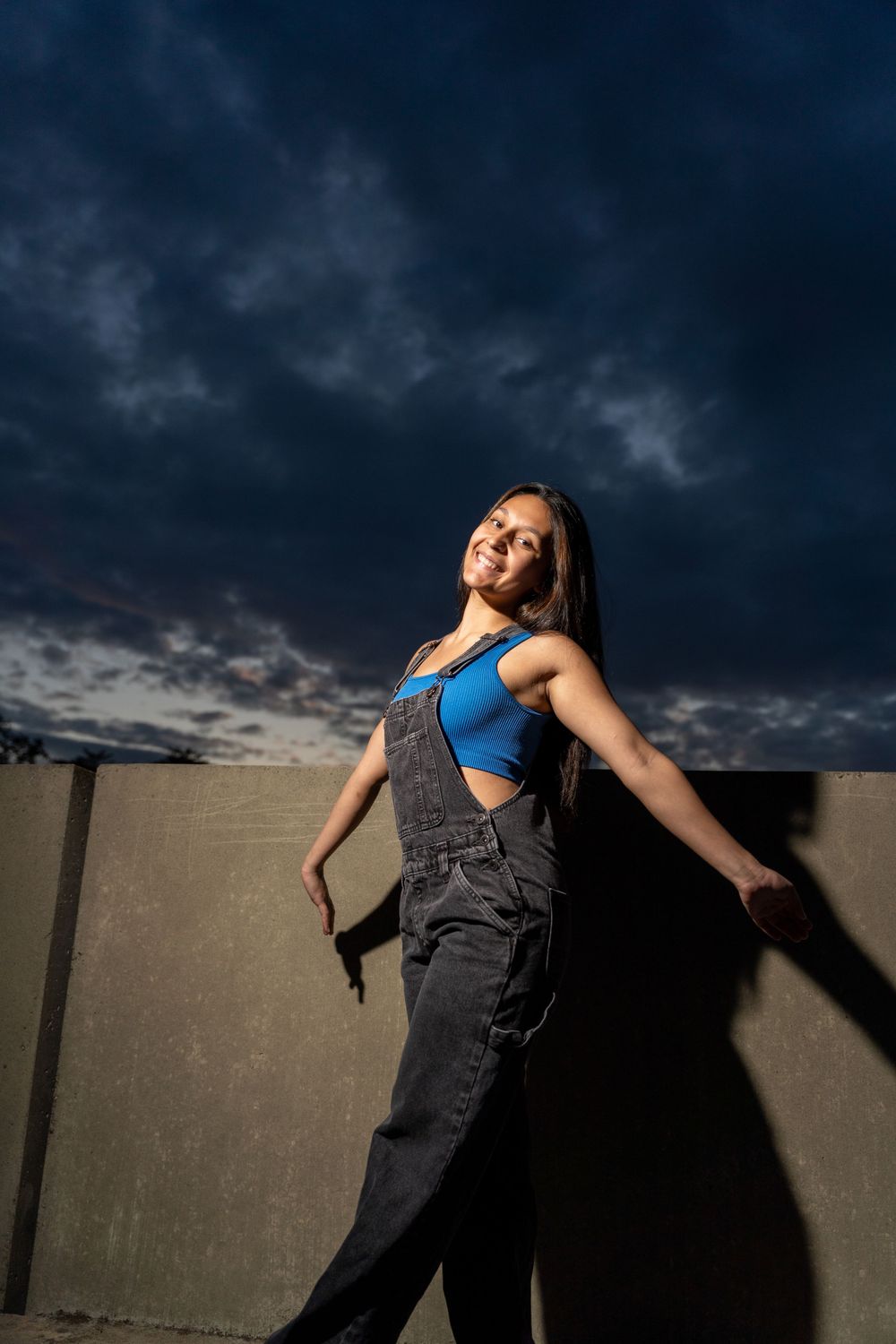 Young woman exuding confidence and style during a captivating night street photoshoot, surrounded by the vibrant city li