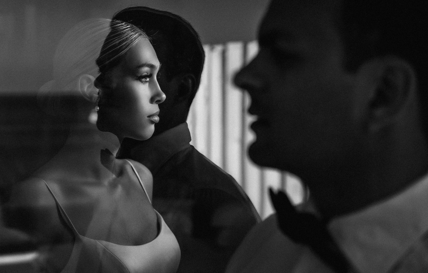 Intimate black and white portraits with dramatic window lighting and shadows.