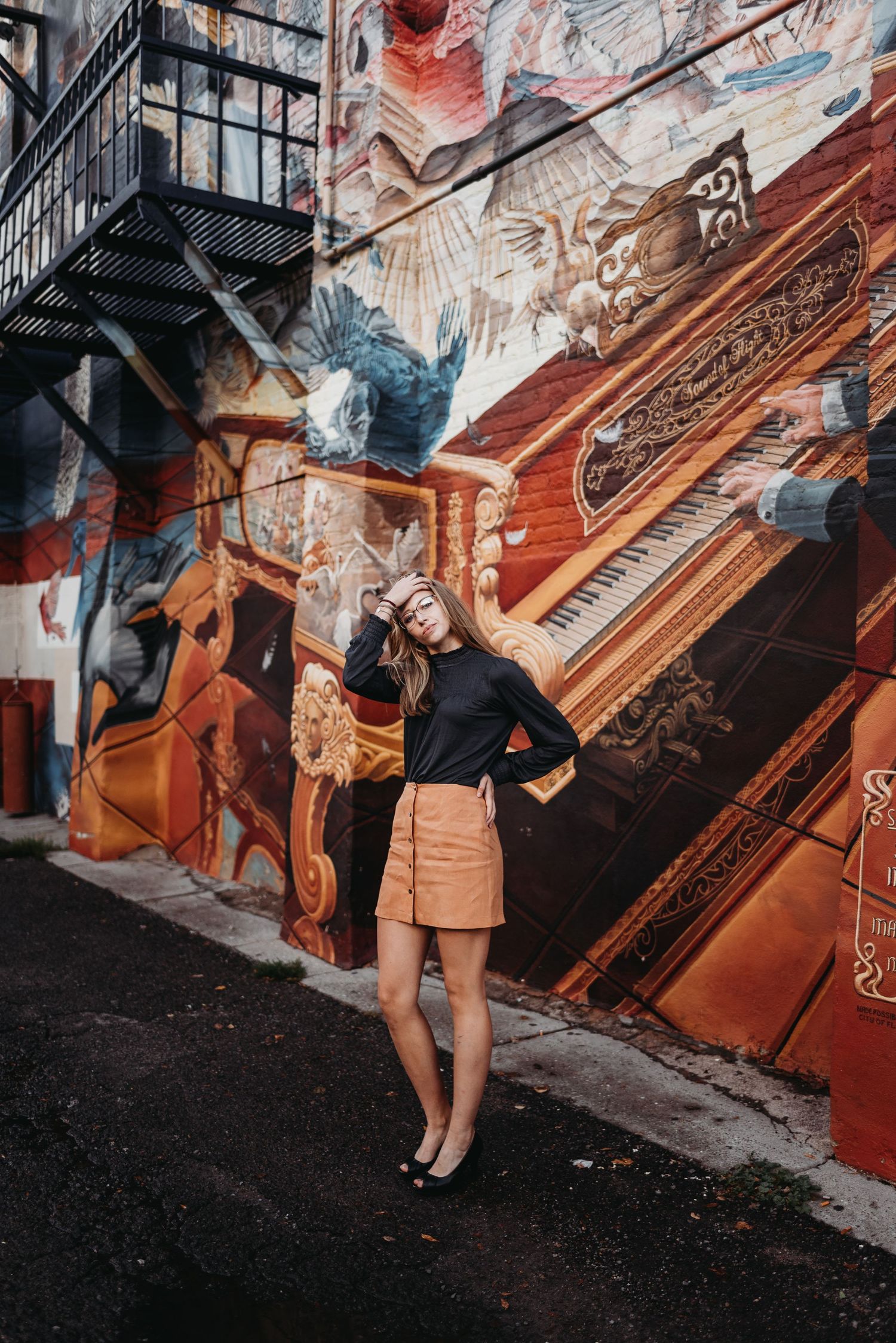 Close-up view of orange and black street art murals on urban walls.