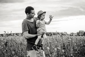 Black and white candid moment captured in wildflower field on sunny day.