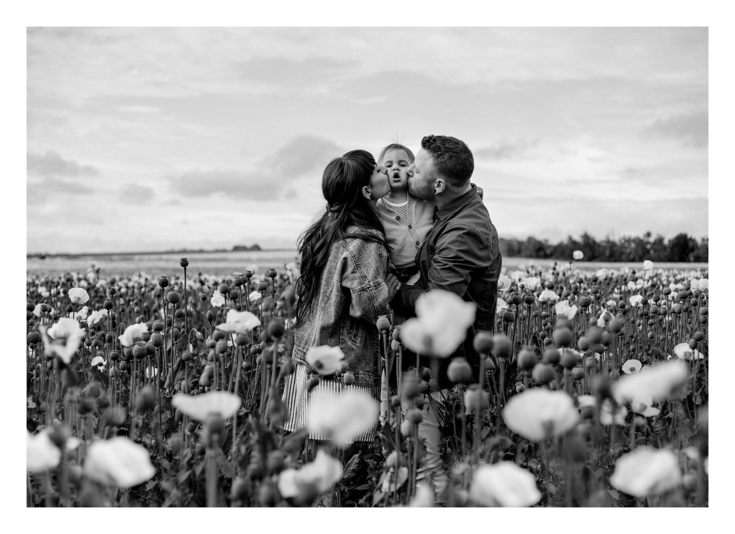 Family sharing tender moment together in blooming poppy field.