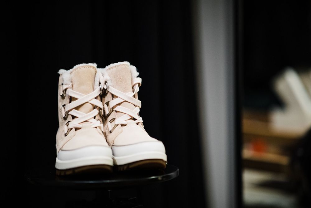 Pair of white vintage-style boots photographed against dark background.