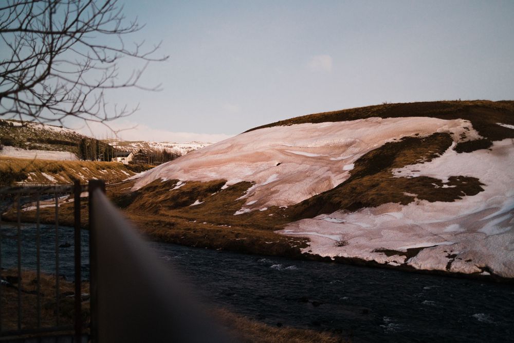 Snow-covered landscape with river winding through winter terrain.