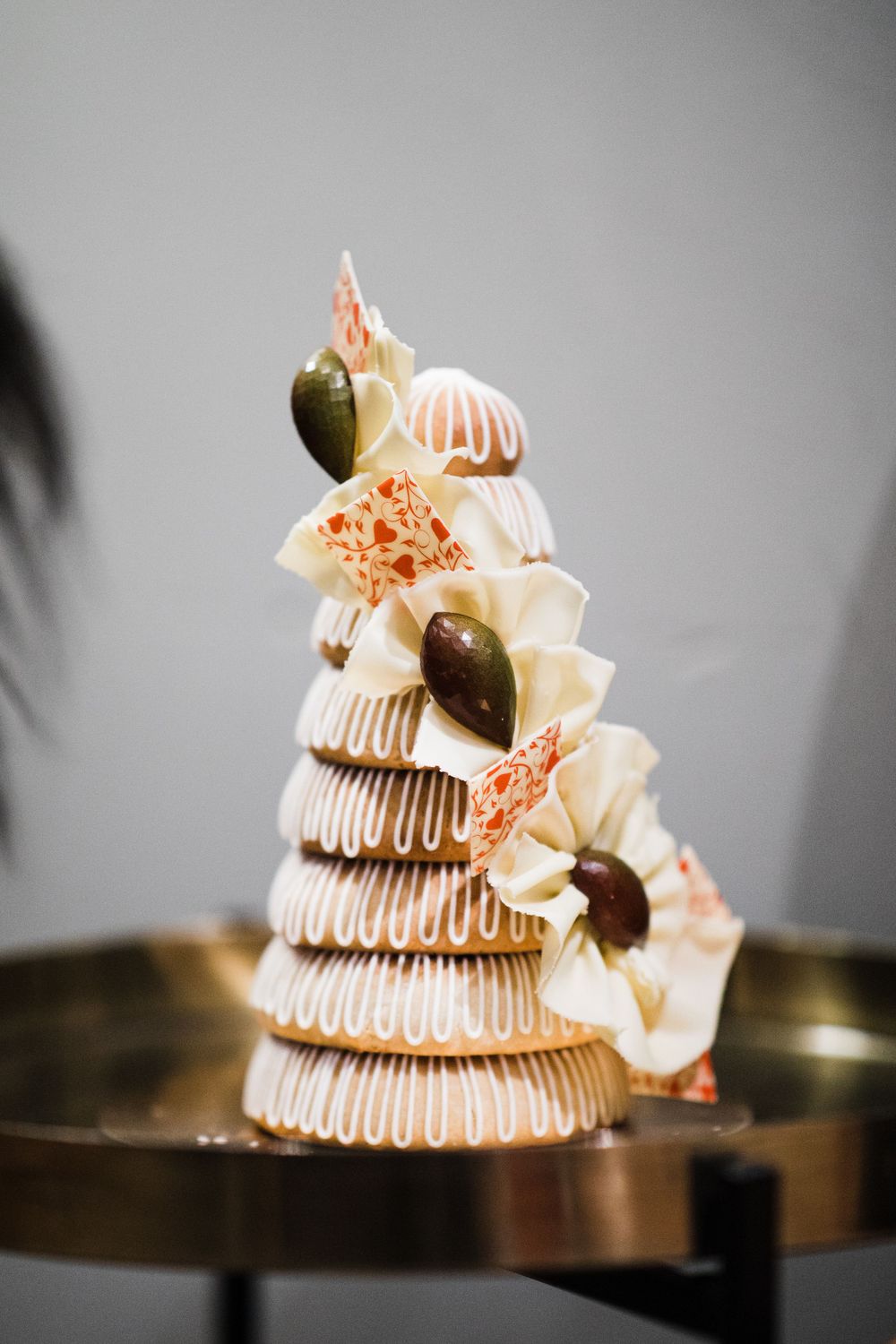 Elegant tiered wedding cake decorated with white frosting and olive garnishes.