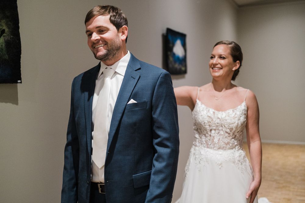 Newlyweds share first look moment in elegant formal attire.