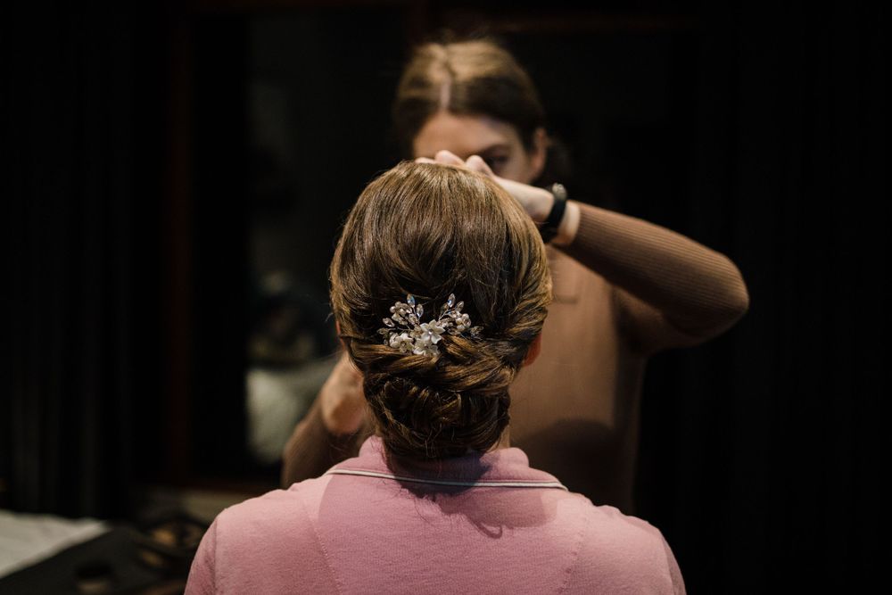 Wedding day hair preparation showing an elegant updo with crystal hair accessory.